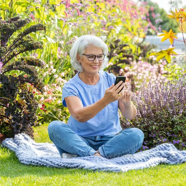 Gartenfreizeit - Frau mit Handy im Garten